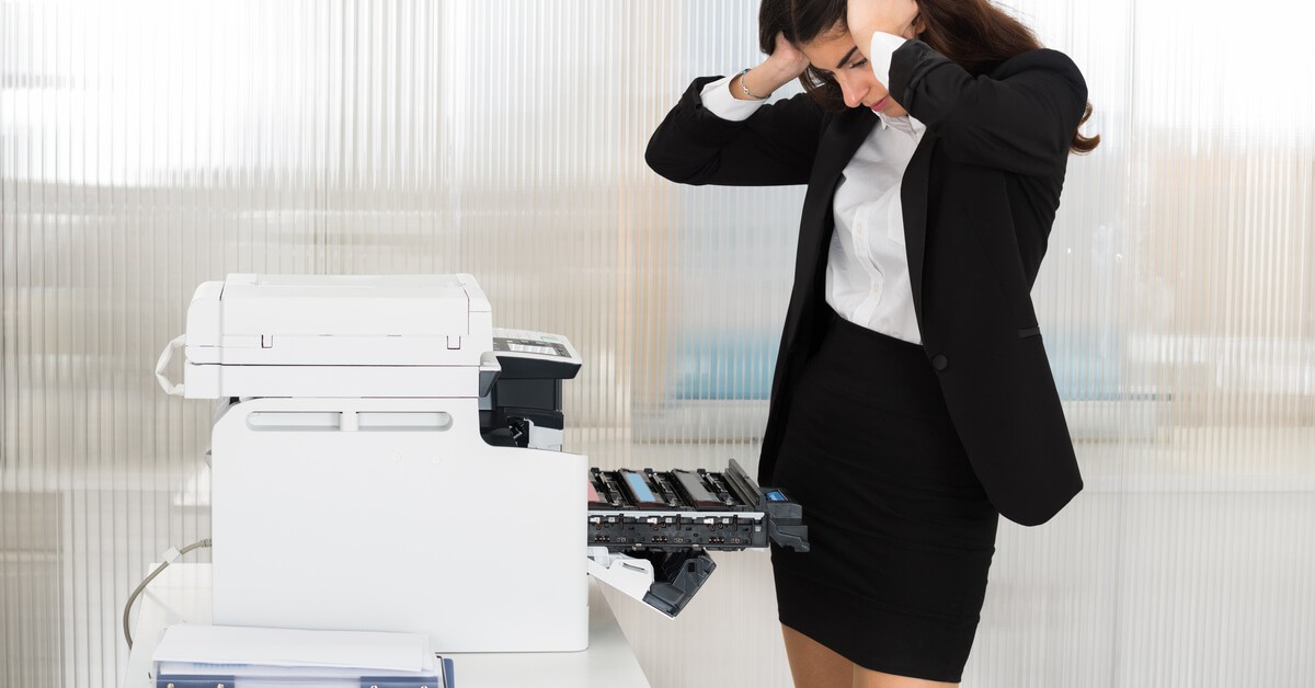 woman in business attire frustrated with a faulty office printer