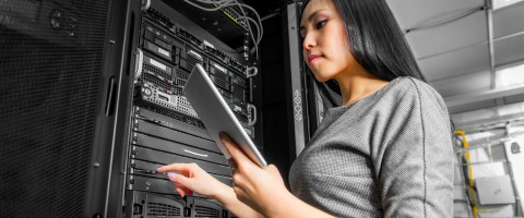 woman working in server room with tablet