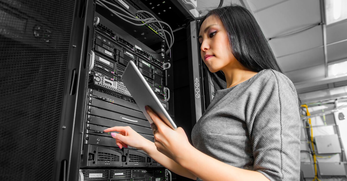 woman working in server room with tablet