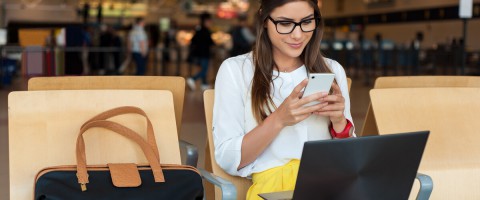 caucasian business woman in glasses on phone and laptop in an airport