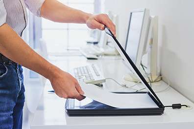 Close-up image of an office worker using an office flatbed scanner