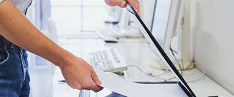 Close-up image of an office worker using an office flatbed scanner